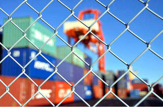 cargo container yard behind chain link fence