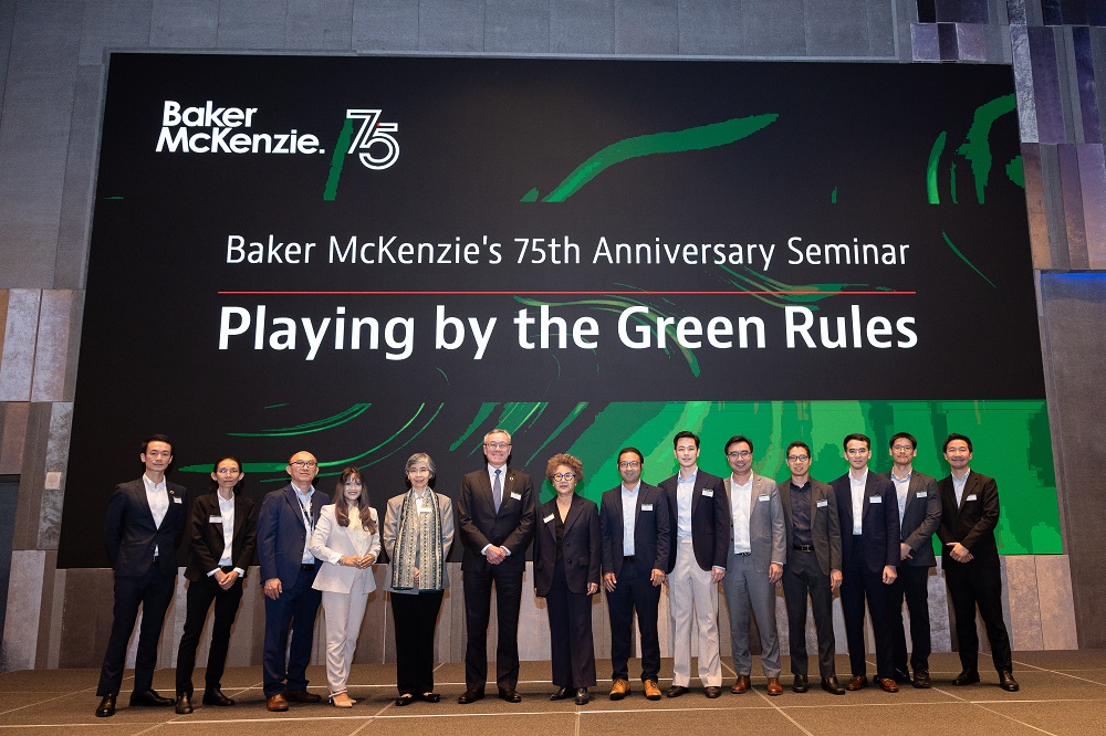 Lawyers standing in front of the banner for a 75th anniversary seminar